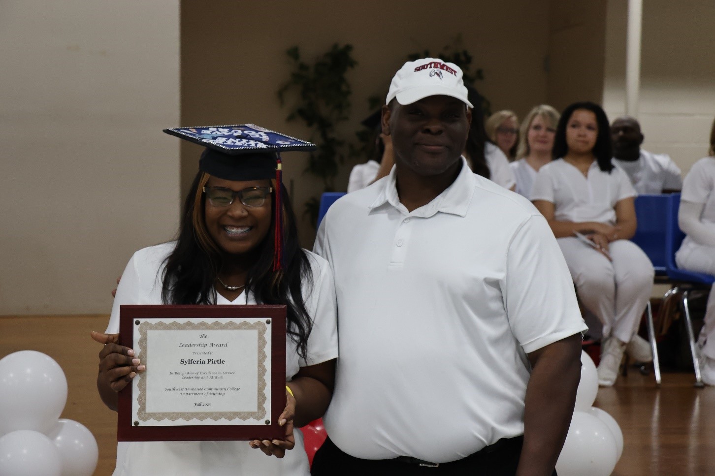 Student Nursing Government Association President Sylferia Pirtle receives her certificate for academic excellence from Department Chair, Dr. Marlon Gibson.