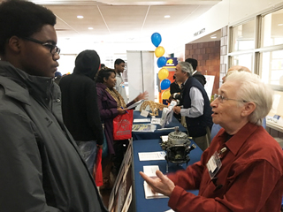 Bartlett High School senior Wilson Reed whose interest is music and animation, talks to Assistant Professor of Information Technology and Networking Brenda Phillips.