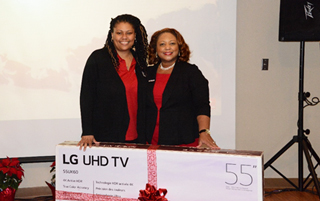 President Tracy D. Hall presents Johnice Mottley her prize of a 55-inch television. 