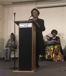 Bertha Rogers Looney addresses a capacity crowd at the Share the Love award celebration Feb. 7 inside the M Auditorium on the Union Avenue Campus. Seated are Valetta Brinson and Joanitha Barnes.  