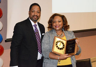Project M.O.S.T. Counselor Sherman Robinson presents President Tracy D. Hall with the Distinguished Senior Staff award. 