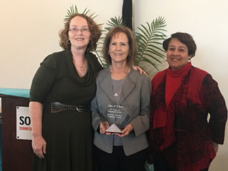 Karen Nippert with her retirement plaque surrounded by colleagues Executive Director of Institutional Advancement Rose Landey and Advancement Specialist Frances Bullock.  Landey worked with Nippert for 11 years. “Karen was an exceptional boss, full of compassion for her team and the students.” 