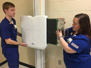 Radiology Club Vice President Colin Mattix and club president Carrie Ross demonstrate how to use the new digital imaging equipment.