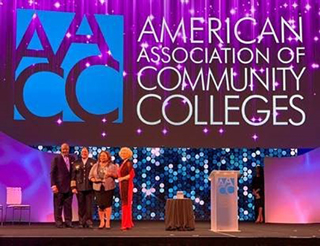 Police Services/Public Safety Department Director Angela Webb and President Tracy D. Hall (middle of photo) receive the Community College Safety, Planning and Leadership Award at the 2019 AACC Awards of Excellence.