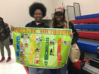 Students hold the 2019 Earth Day Dash 5K poster. 