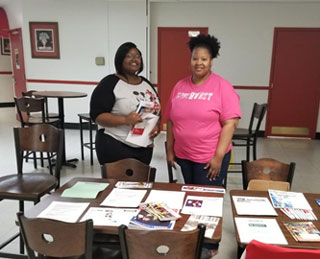 Mentors Jessica McVey and Kazia Mobley prepare a resource table for their mentees on the Union Avenue Campus. 