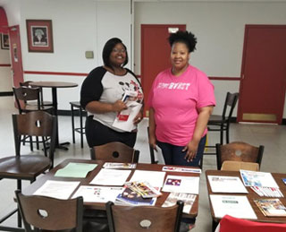 Mentors Jessica McVey and Kazia Mobley prepare a resource table for their mentees on the Union Avenue Campus.