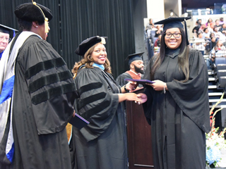 President Tracy D. Hall hands out diplomas to members of the Class of 2019