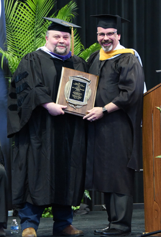Charles Baker receives the William W. Farris Faculty Service Award from Faculty Support Dean Jeremy Burnett.  