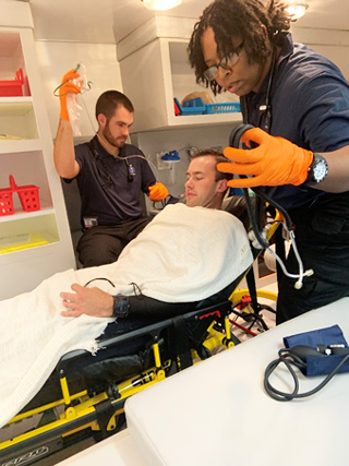 EMT students Cole Gwin and Destinie Ransom stabilize their “trauma victim” classmate Noah Johnson.