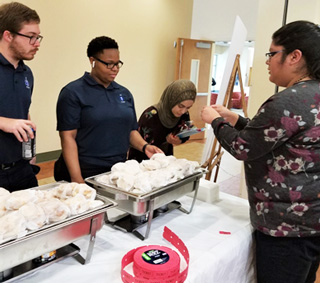 Retention and Student Success Program Specialist Alma Hernandez (right) hands out tickets for the t-shirt drawing on the Maxine A. Smith Campus.