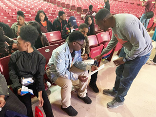 Associate Director of K-12 Community Partnerships Shawn Boyd helps a graduating senior at Melrose High School prepare to register for classes during NSO on the Go.
