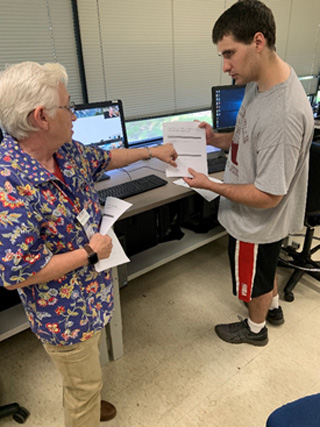 Brenda Phillips, assistant professor of networking, reviews sample questions on the CompTIA certification test with Zachary Paulson during the A+ hardware boot camp.