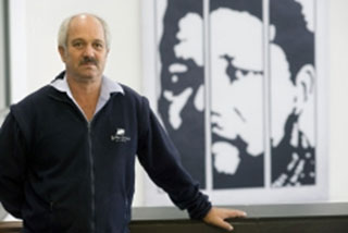Author Christo Brand in front of a backdrop of imprisoned Nelson Mandela.