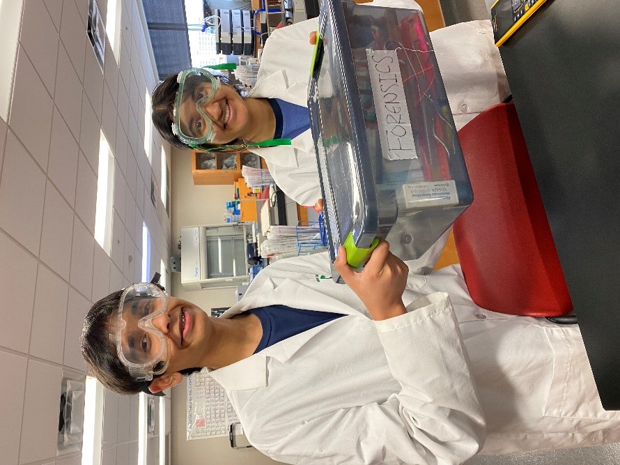 Two students pose with a forensics project at the regional Science Olympiad Tournament.