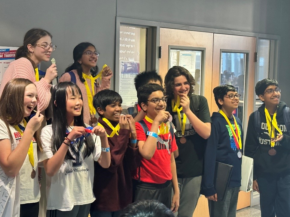 A group of students from Houston Middle School proudly hold their Science Olympiad awards.
