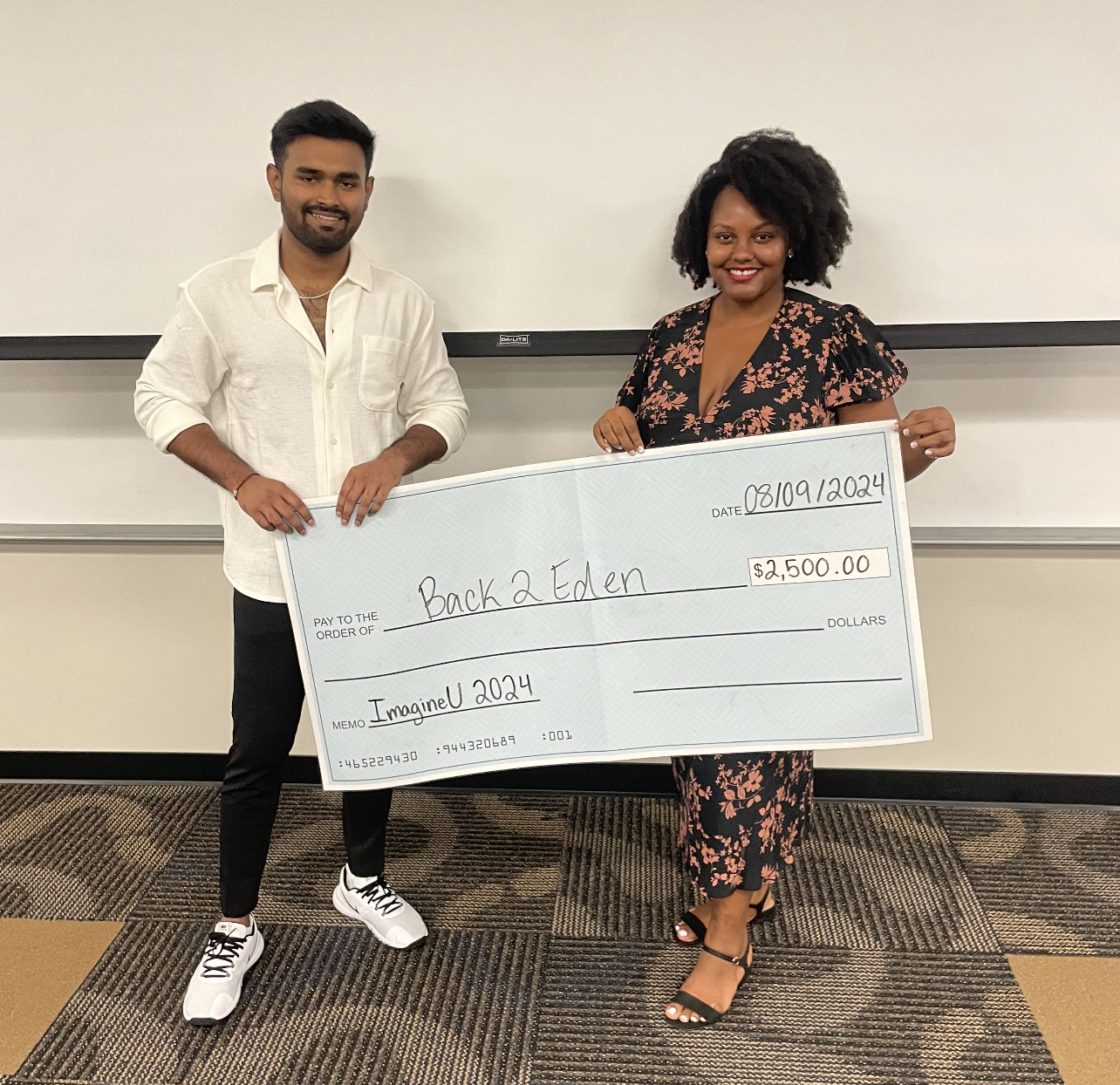 Saia Reddy and Nacaria Royal receive their prize money at the Imagine U Summer Entrepreneurship Awards held at the University of Memphis.