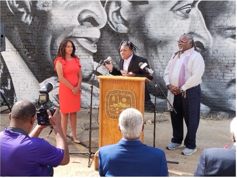 Group of people standing in front of a mural depitcint fatherhood