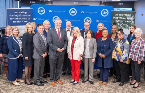Large group of professionally dressed educators and healthcare leaders standing together at a formal event in front of branded banners reading “Innovating Nursing Education for the Future of Health Care” and “Accelerating Innovation from Classroom to Care,” highlighting collaboration, nursing education leadership, healthcare innovation, and institutional partnership in an academic conference setting.